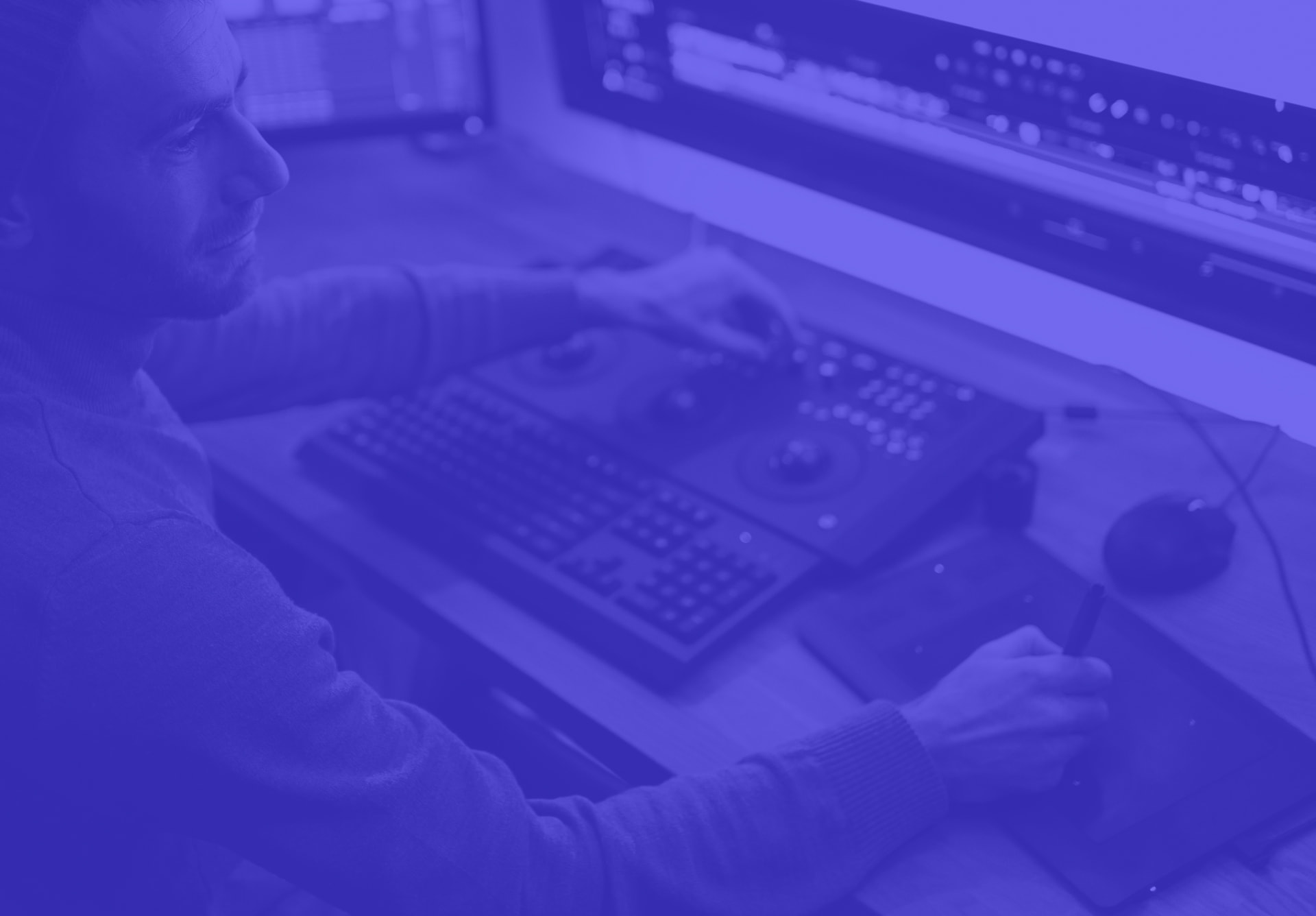 Colourist at a grading control surface in a professional post-production suite